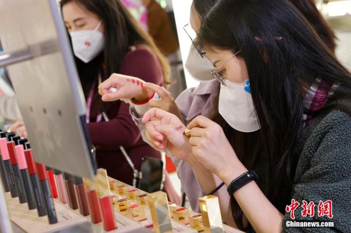 圖為女生正在體驗(yàn)口紅產(chǎn)品。 殷立勤 攝