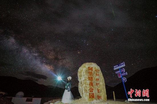 圖為6月20日晚，游客“打卡”西藏阿里暗夜公園，天上是銀河與流星（右上角）。曹枝清 攝