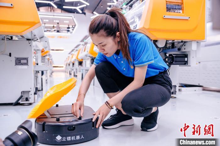 圖為員工在調(diào)試AGV搬運機器人?！±钅宪?攝